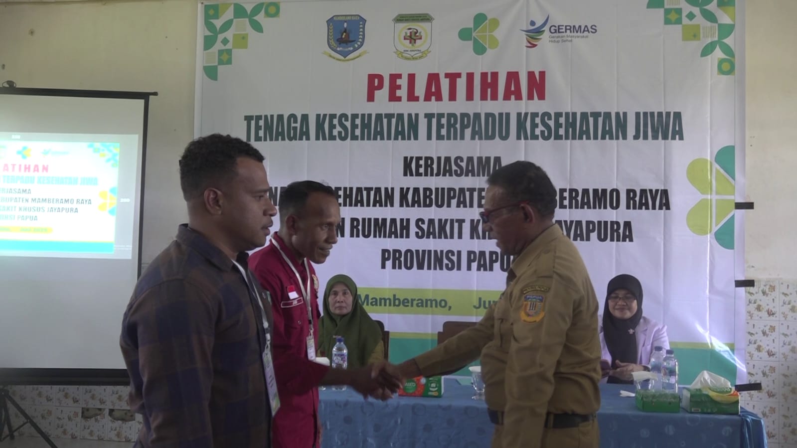 Kepala Dinas Kesehatan Kabupaten Mamberamo Raya dr. Yermia Msen, M.Kes, melakukan penyematan tanda peserta kepada 2 perwakilan peserta pelatihan tenaga Nakes terpadu kesehatan jiwa dikasonaweja kamis 24/6/2025