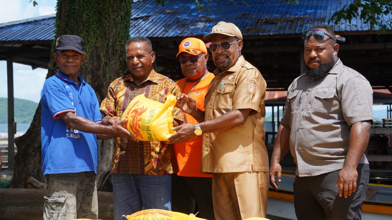 Bupati Jayapura Dr. Yunus Winda, MH., menyerahkan bantuan sembako di Sentani Timur