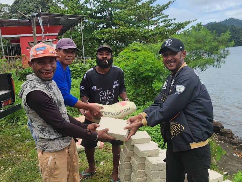 Penyerahan bantuan baru tela dan semen secara simbolis oleh Sekretaris DPD HPP Papua Moeis Marcellino Marini