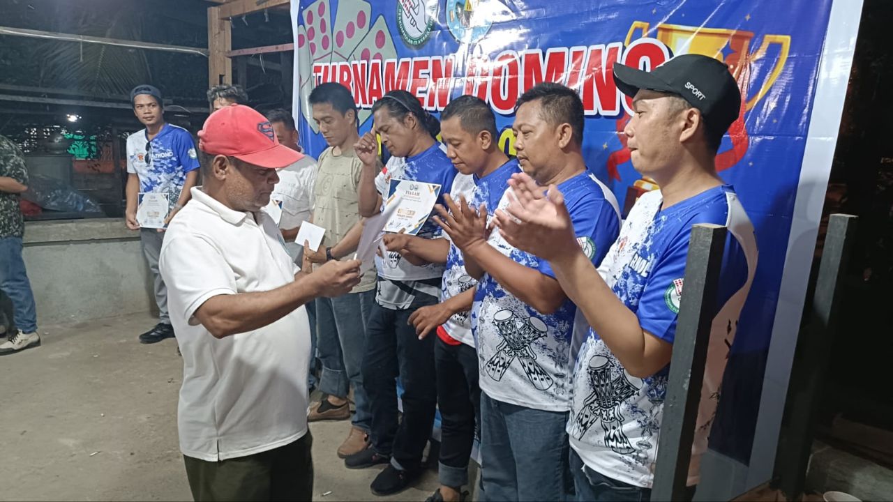 Tampak Viktor Burdam menyerahkan piagam dan juga uang pembinaan kepada juara Domino Cup I