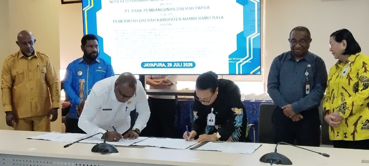 Tampak Bupati Robby Rumansara, SP., MH., bersama Direktur Bank Papua Yuliana Yembise, MH., ketika melakukan penandatanganan MoU